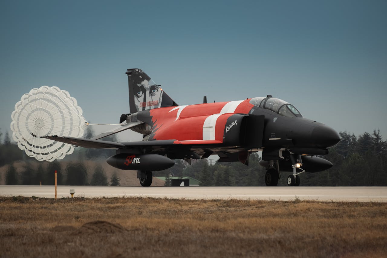 Home Turkish Air Force jet landing with parachute deployment on a runway.